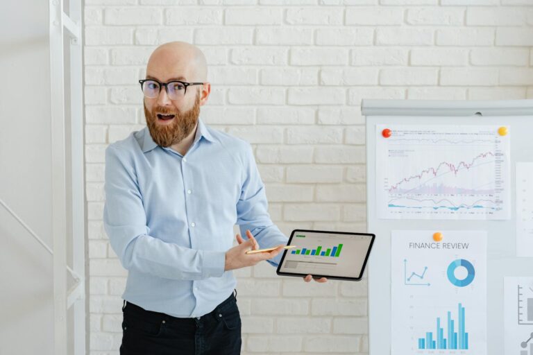 a man in blue long sleeve shirt holding a tablet with a chart on screen